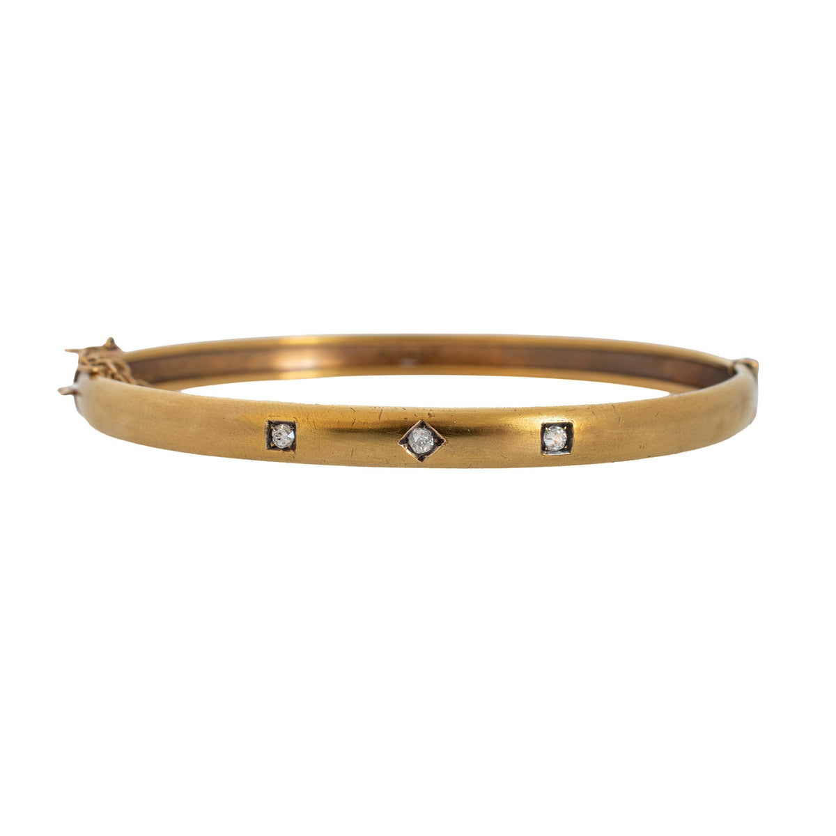 Victorian 15K yellow gold bangle with three diamonds in square and diamond-shaped settings across the front.