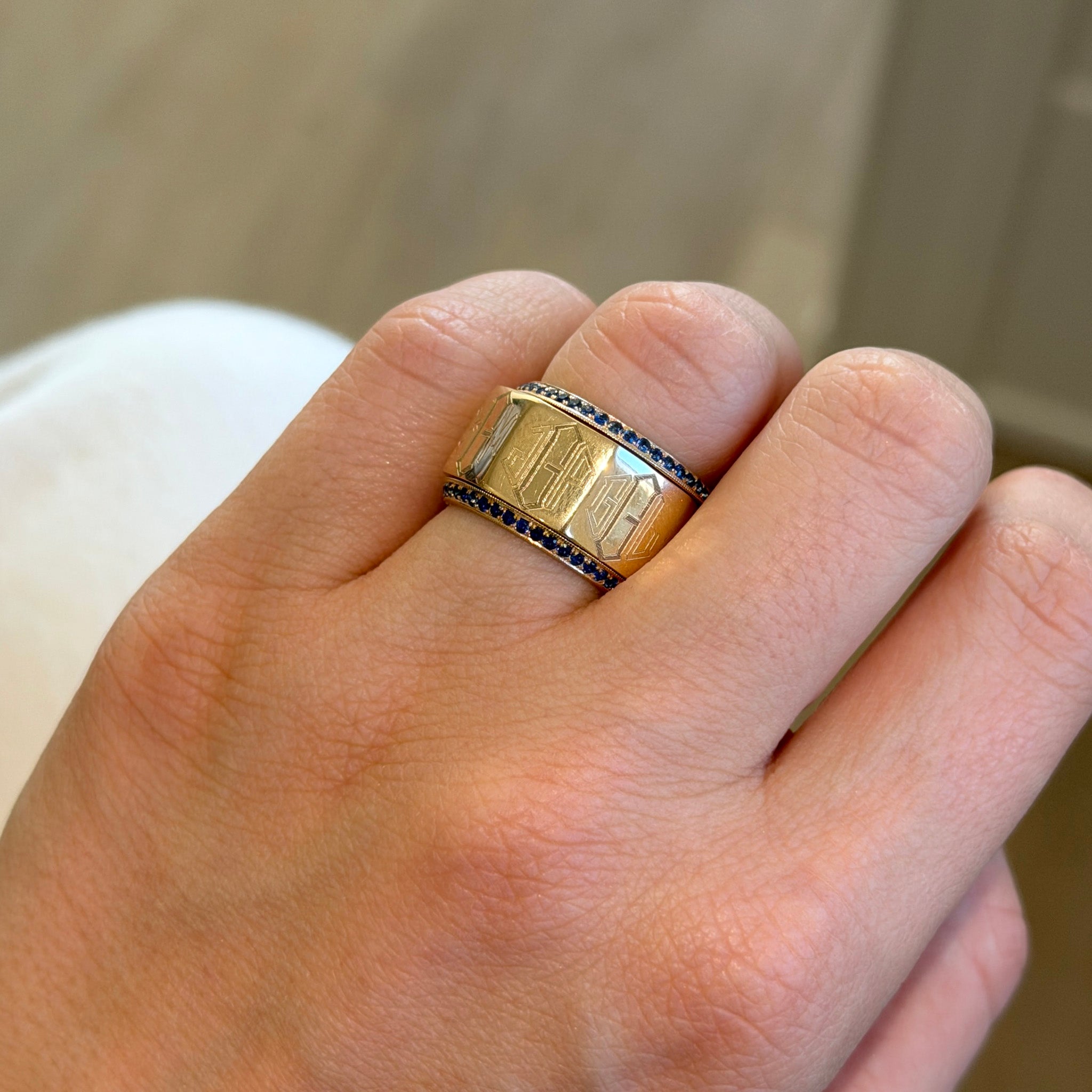 Sapphire 14K Yellow Gold Milgrain Angled Eternity Band guards and Engraved Family Ring stack on a hand
