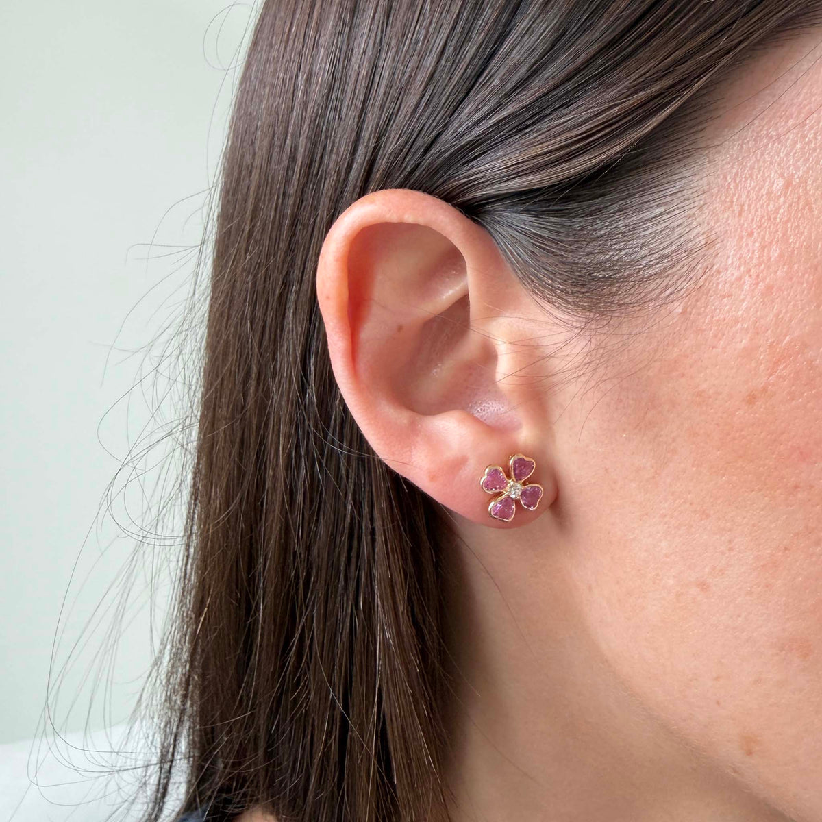 Pink Sapphire & Diamond 14K Gold Clover Stud Earrings on a model's ear.