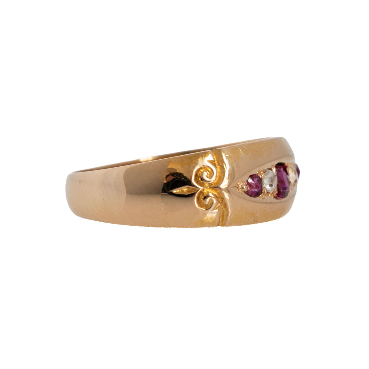 Angled view of Victorian ruby and diamond 18K yellow gold ring showing the wide band and engraved scroll detail.
