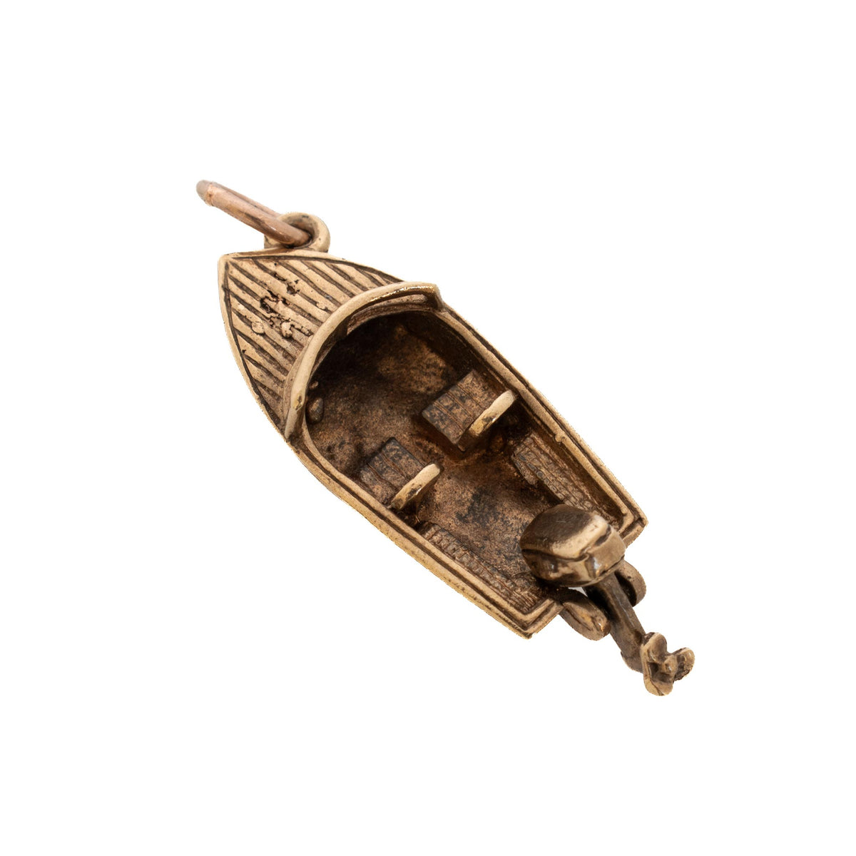 Top view of a vintage 9K yellow gold motorboat charm showing its grooved bow deck, two seats, and outboard propeller.