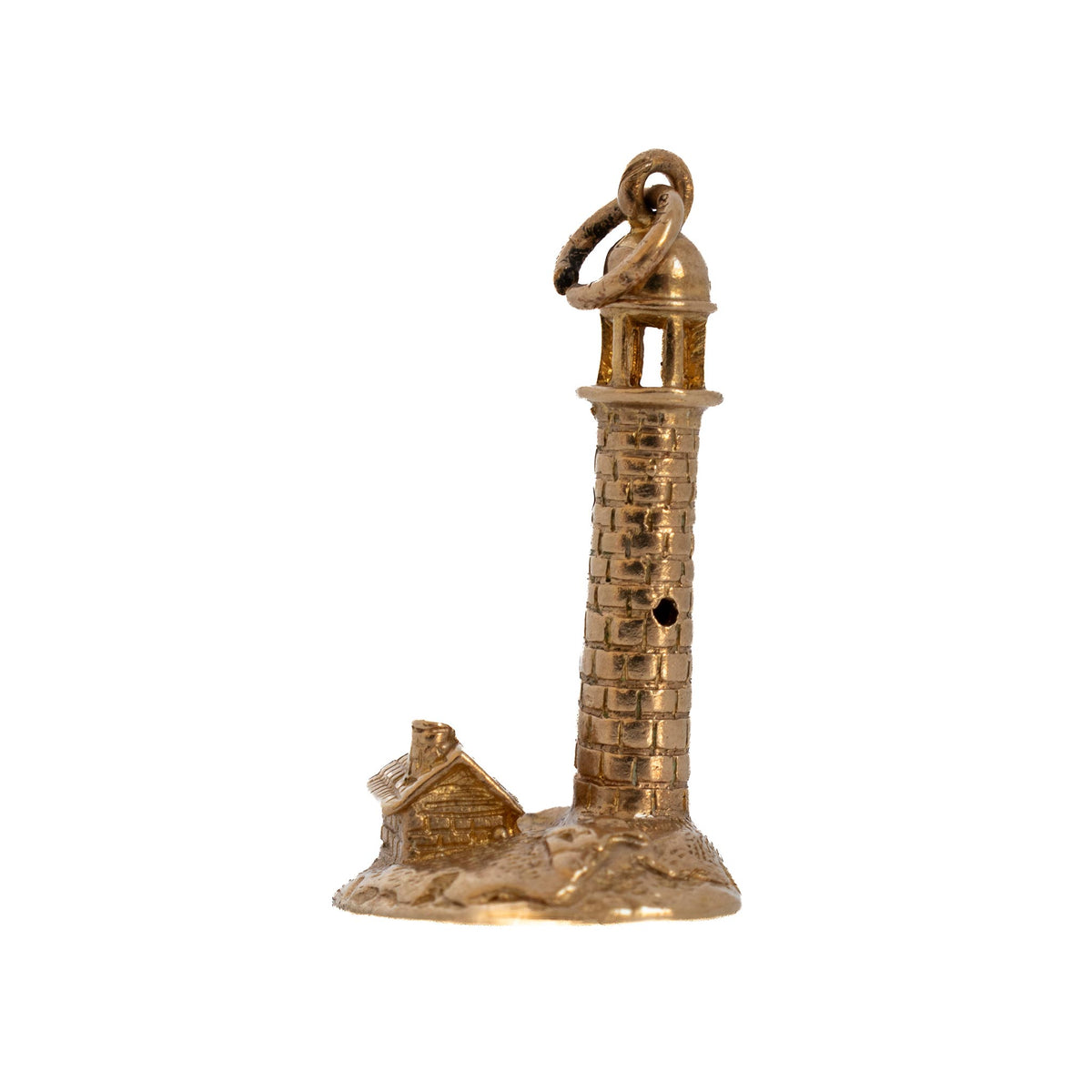 Reverse view of a vintage 9K yellow gold lighthouse charm showing a round tower window and the keeper’s house.
