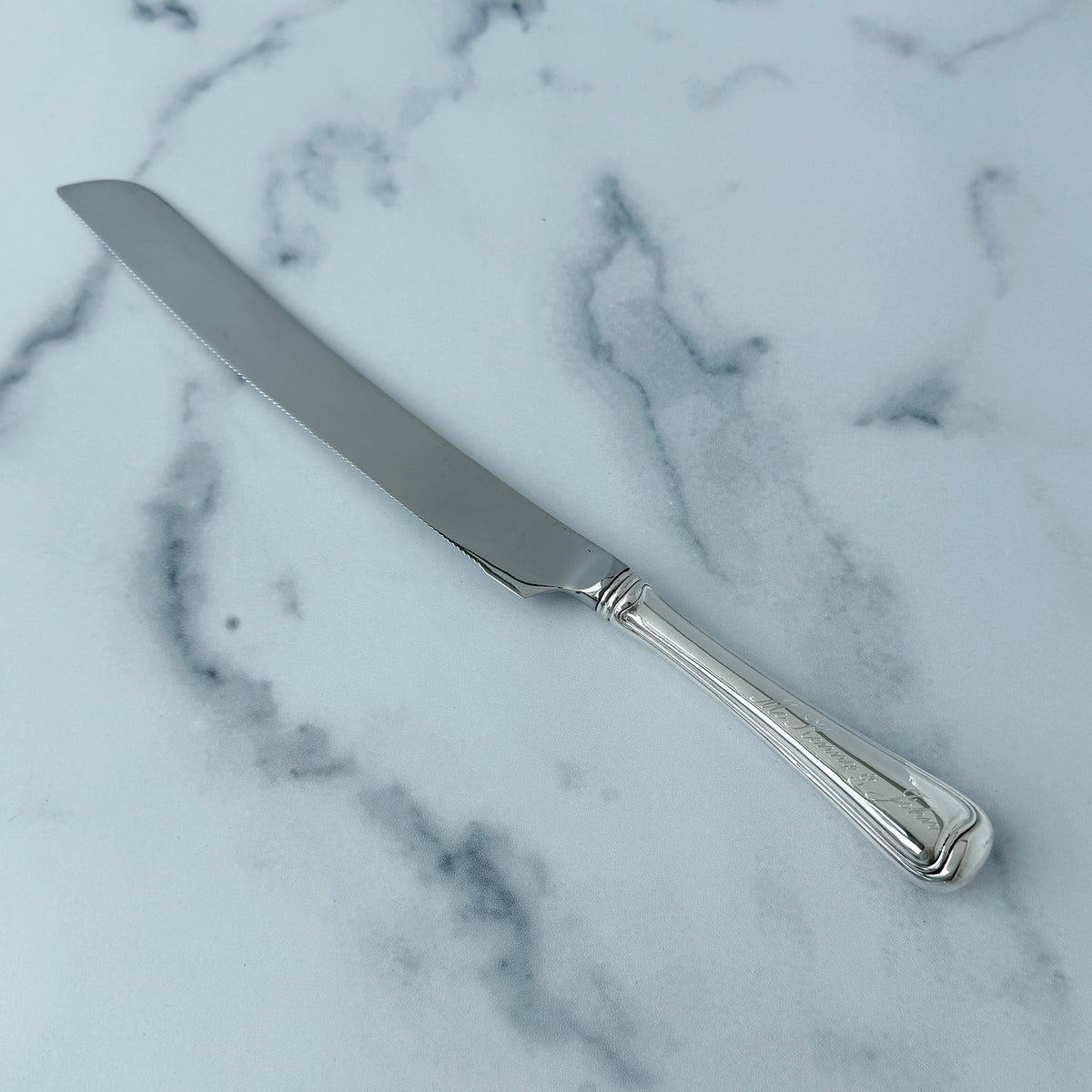 Old French Gorham Sterling Silver Wedding Cake Knife with machine engraved handle on a marble surface