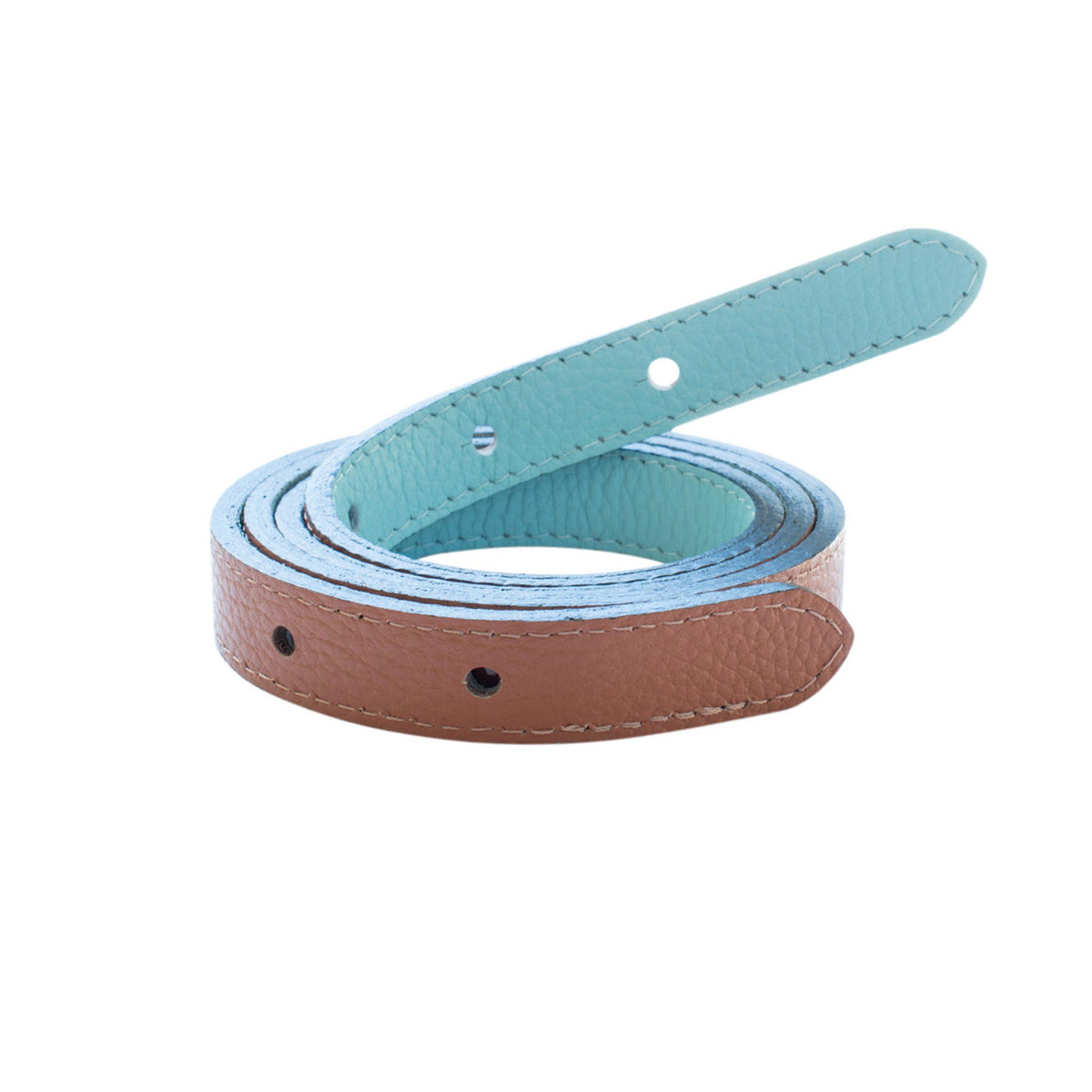 Reversible narrow belt strap coiled to show its saddle brown pebbled leather side and light blue underside.