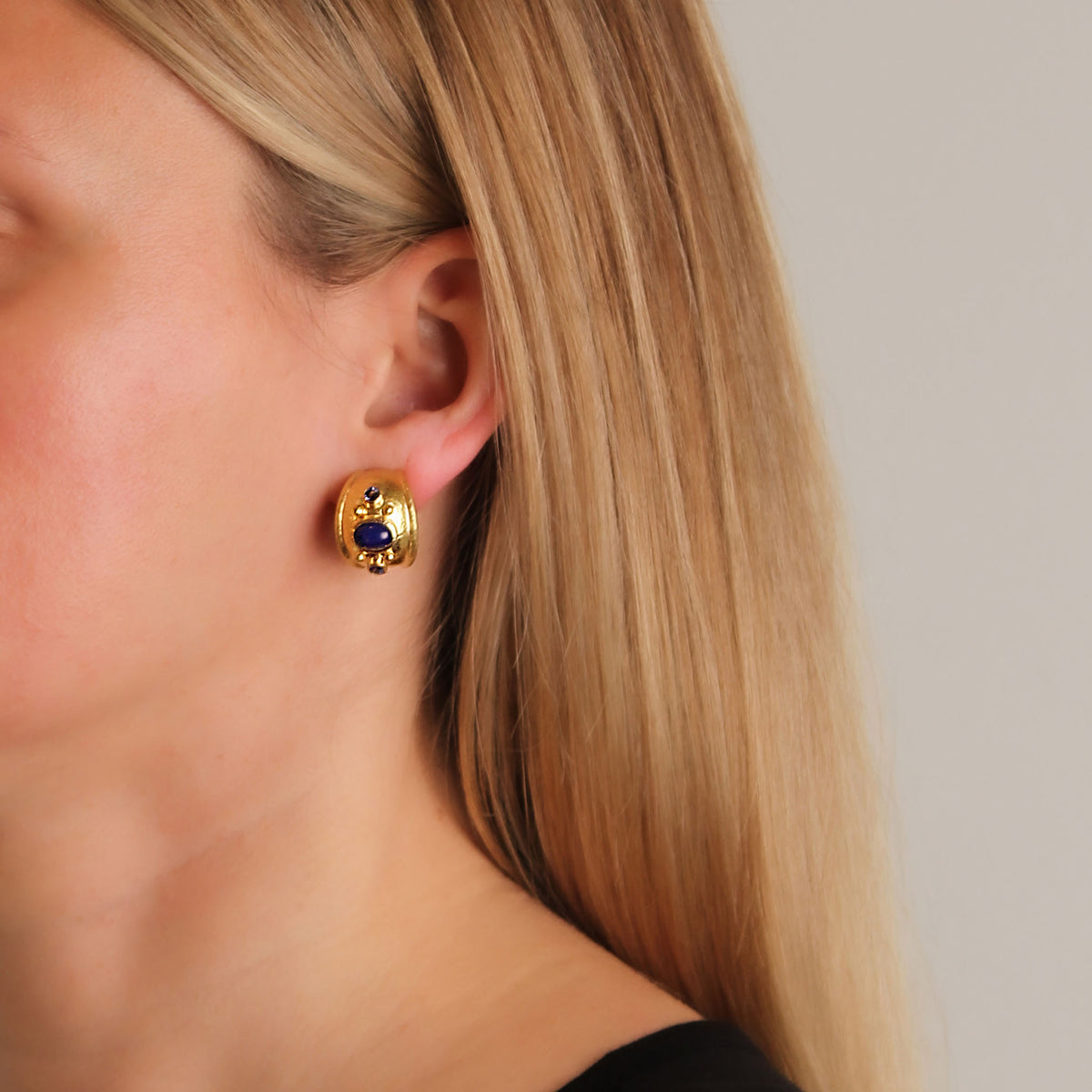 Elizabeth Locke lapis and blue sapphire yellow gold puff earring worn on the ear, showing its size and fit.