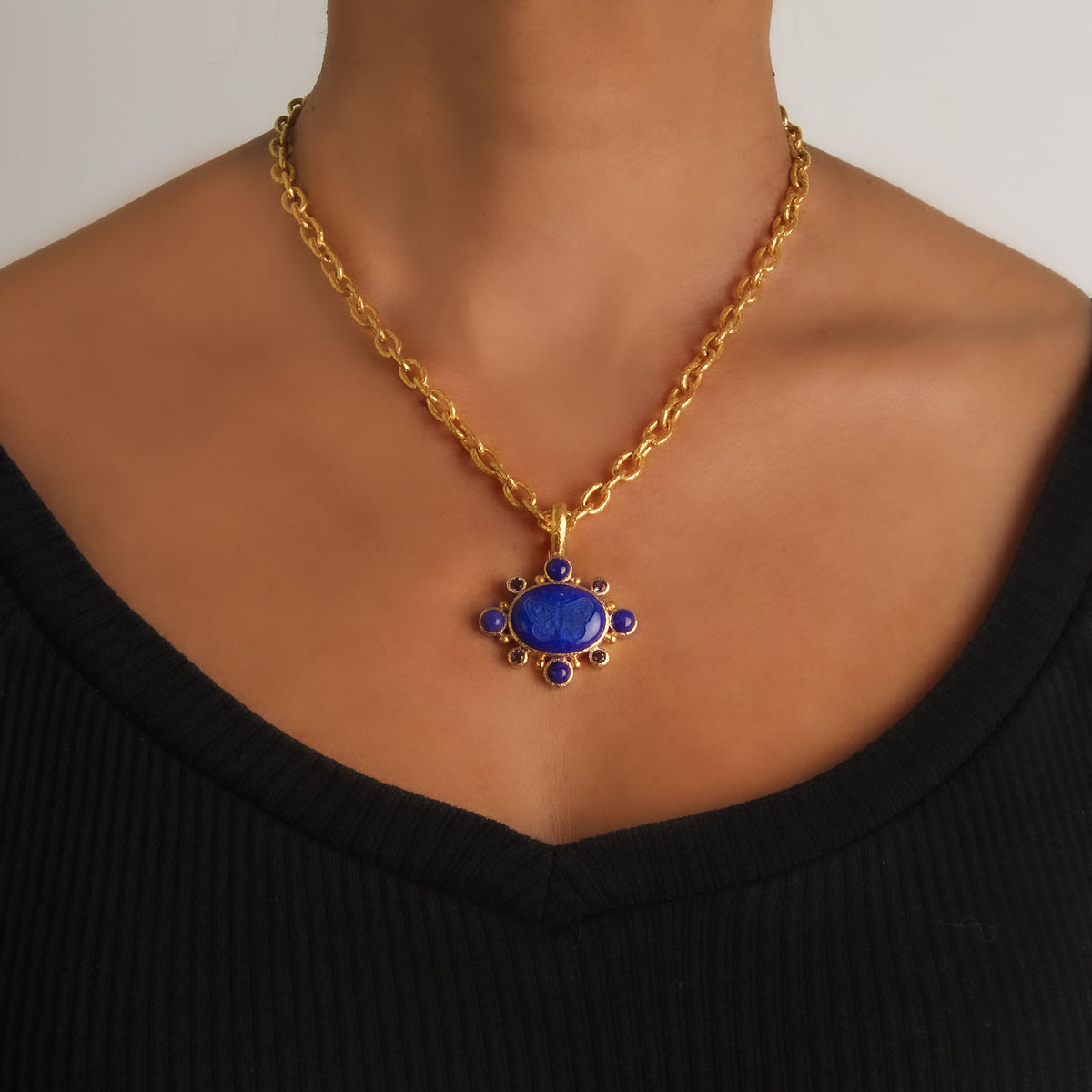 Elizabeth Locke lapis moth and iolite pendant worn on a yellow gold link chain, showing its size and placement.