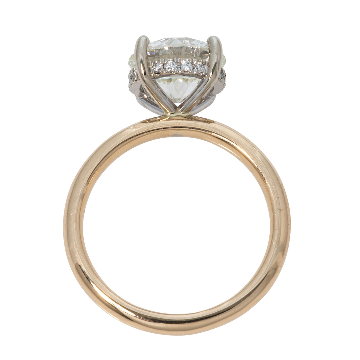 Profile view of a round diamond engagement ring showing the hidden diamond halo beneath the center stone.