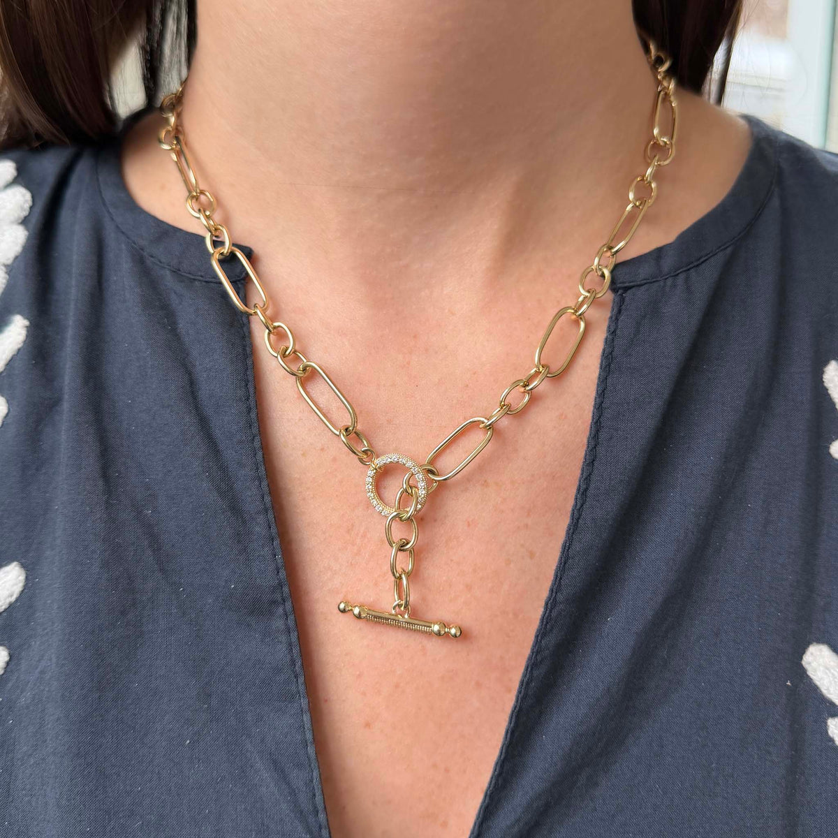 Model wearing a yellow gold mixed link necklace with the diamond pavé toggle clasp hanging at the front.