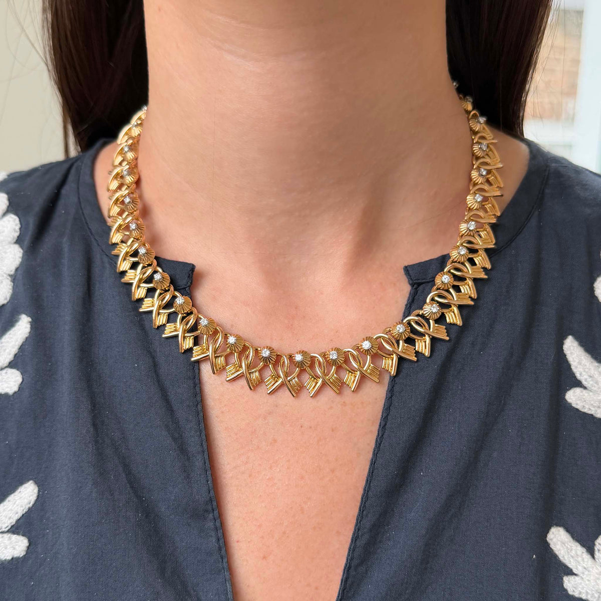 Vintage French 18K yellow gold and diamond link necklace worn at the collarbone, showing its fit and ornate link design.