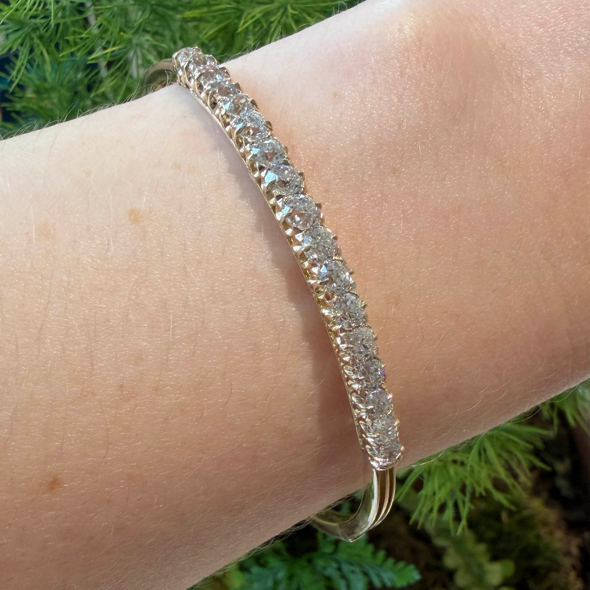 Victorian-style diamond bangle in 14K yellow gold worn on the wrist, showing graduated Old Mine cut diamonds.