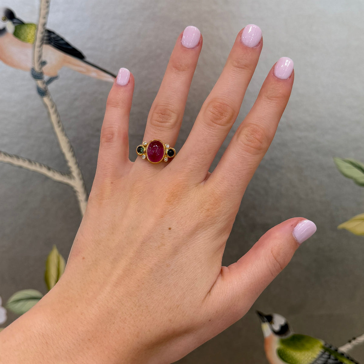 Model with painted nails wearing Pink & Green Tourmaline Three-Stone 14K Yellow Gold Ring on ring finger.