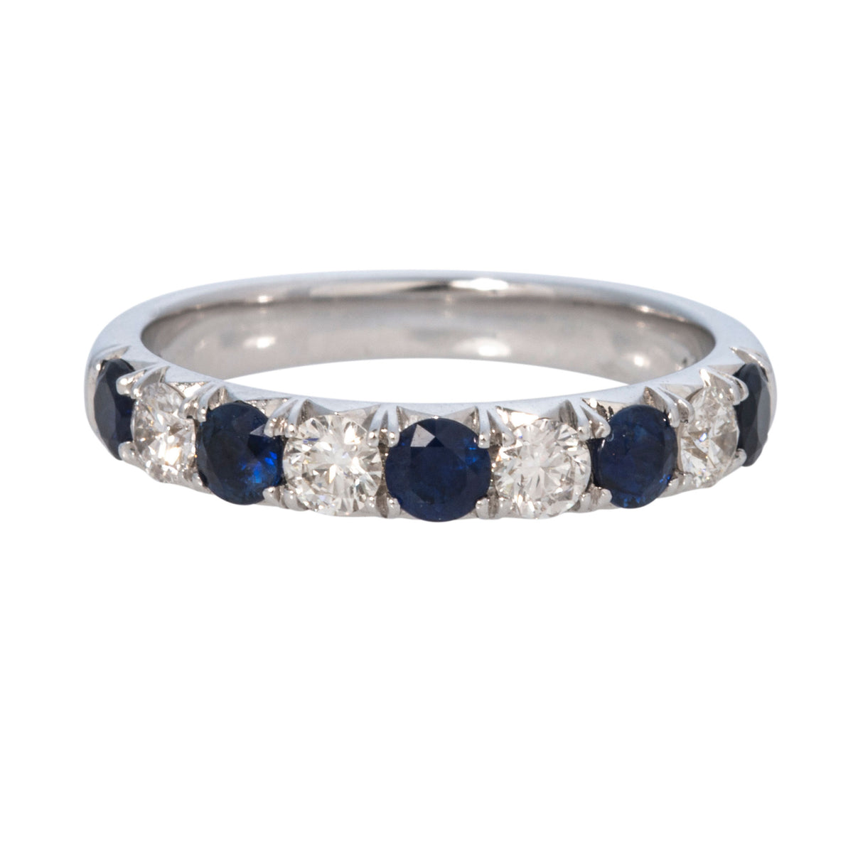 A band ring featuring alternating round-cut dark blue sapphires and clear round-cut diamonds, shown against a plain white background.