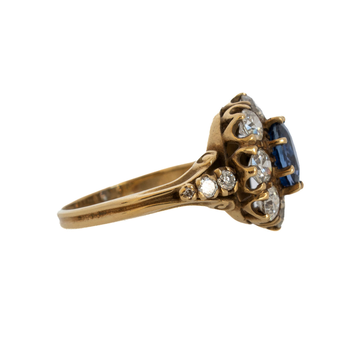 Edwardian sapphire and diamond cluster ring showing the raised openwork gold setting and diamond-set shoulders.