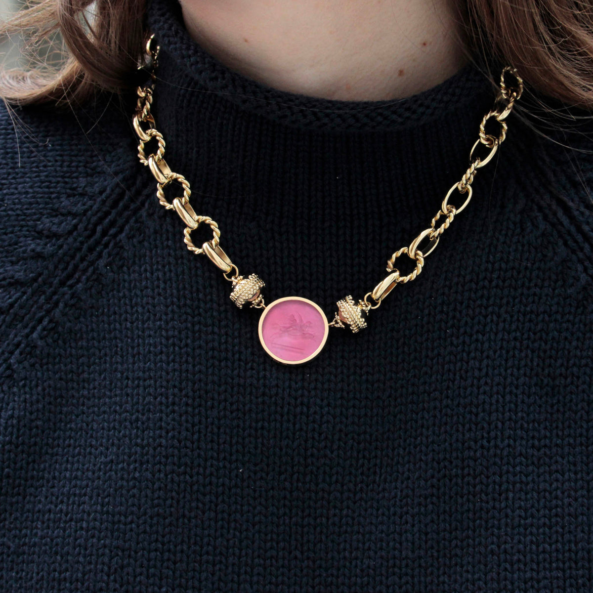 model wearing black knit sweater, and Clara Williams Schiller Necklace with Baby Pegasus Rubellite Chiara Glass 14K Bezel Centerpiece
