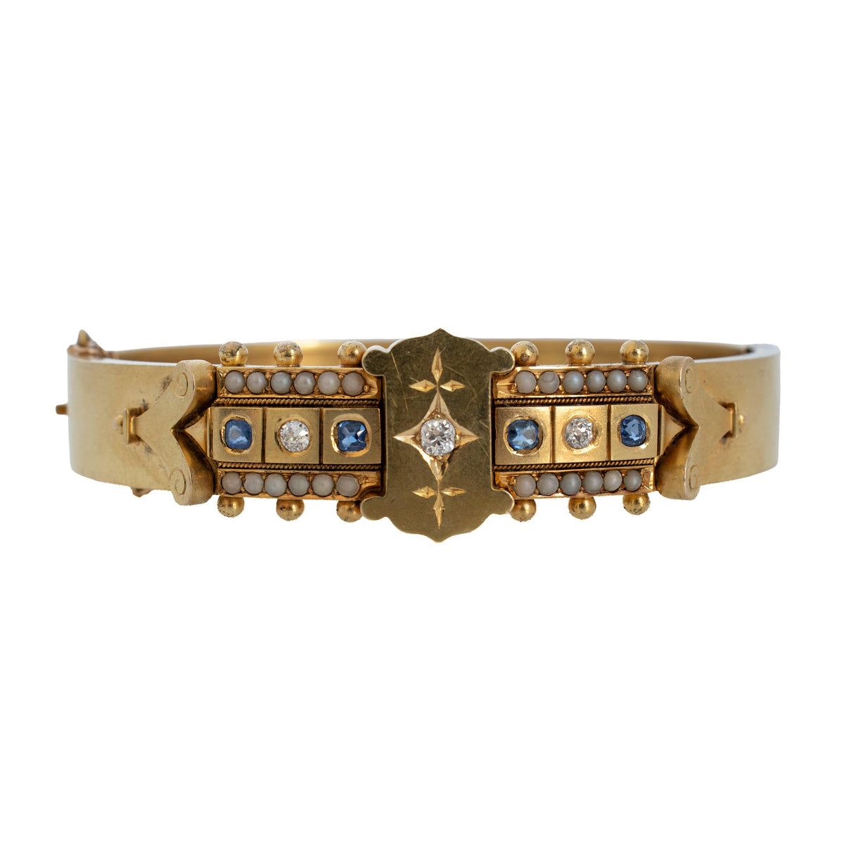 Victorian 14K yellow gold bangle with blue sapphires, diamonds, pearl borders, and a star-set center diamond.