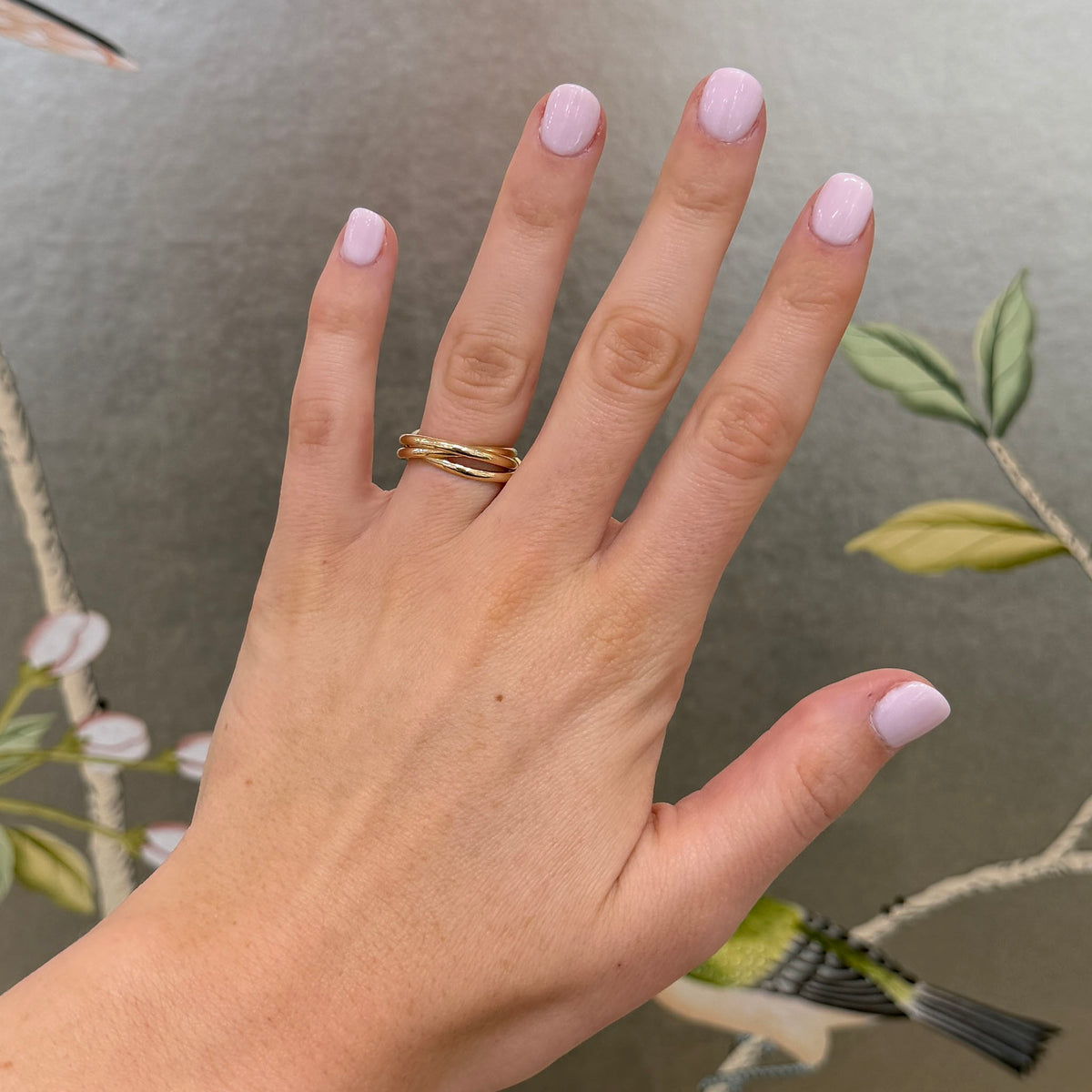 14K yellow gold triple rolling ring worn on a hand, showing its interlocking bands and scale.
