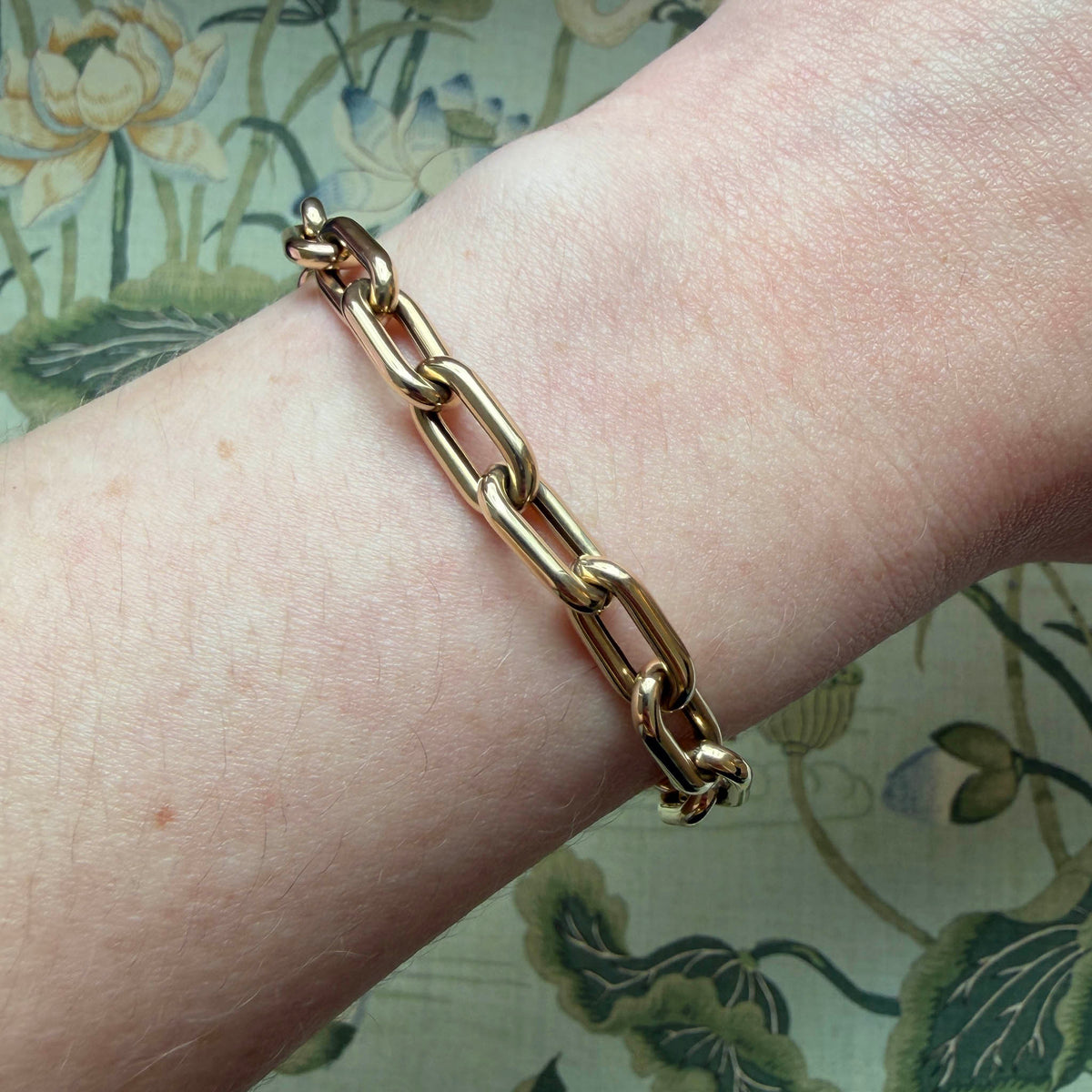 14K yellow gold paperclip link bracelet worn on the wrist, showing its polished elongated links.