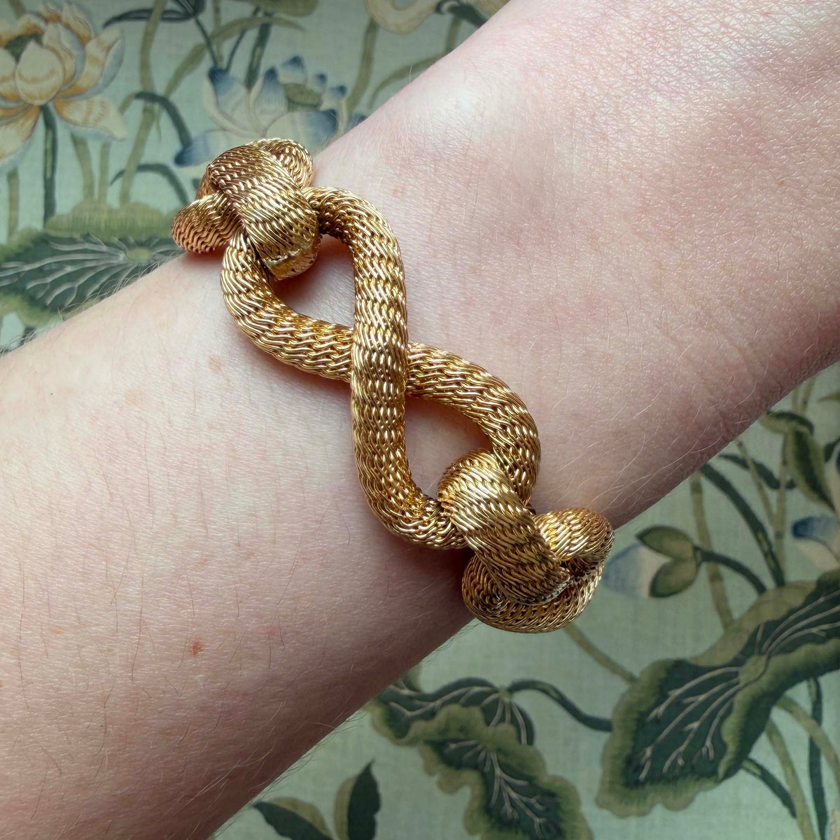 Vintage Filippini woven link bracelet in 18K yellow gold worn on the wrist to show its scale and texture.