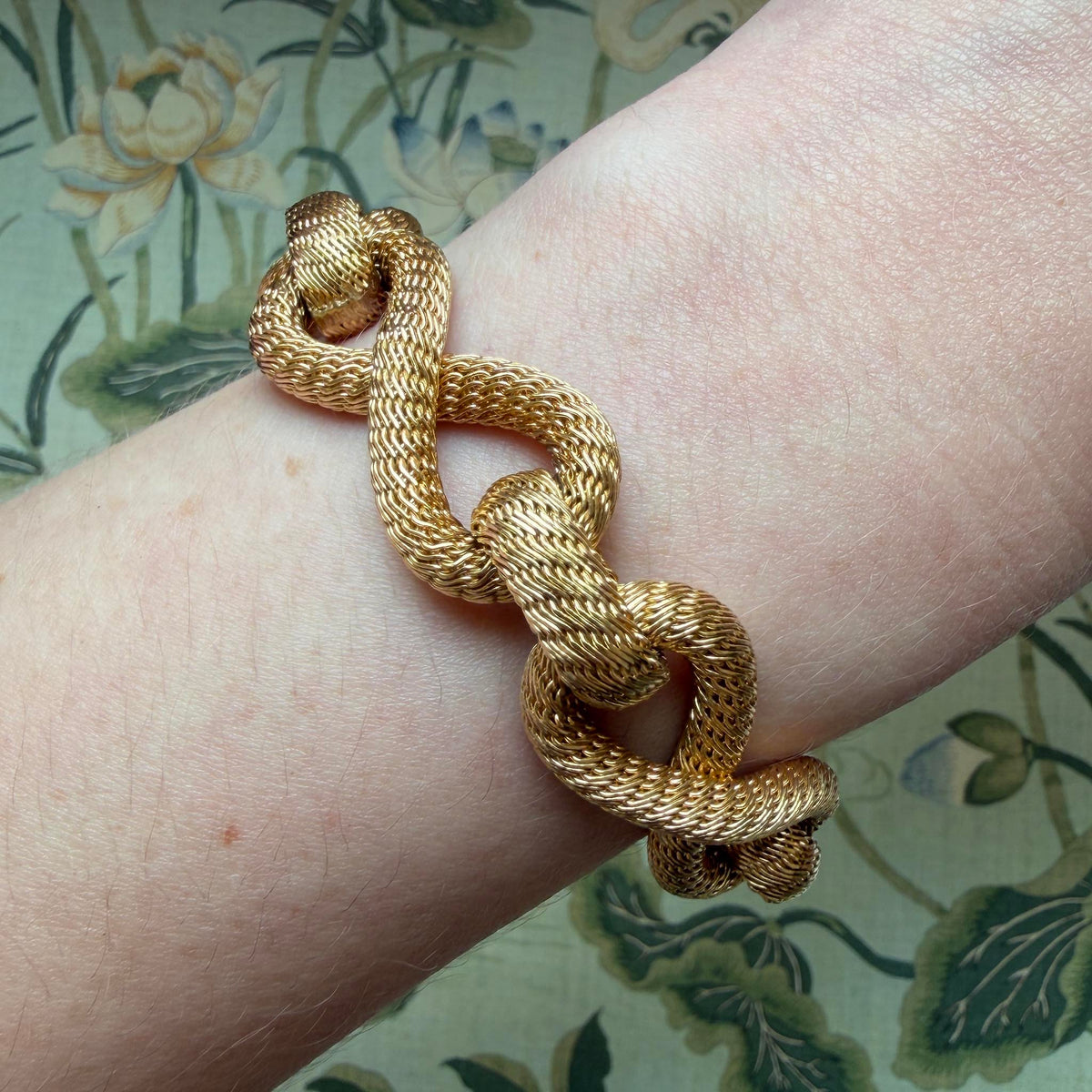 Vintage Filippini woven link bracelet in 18K yellow gold worn on the wrist to show its scale and texture.