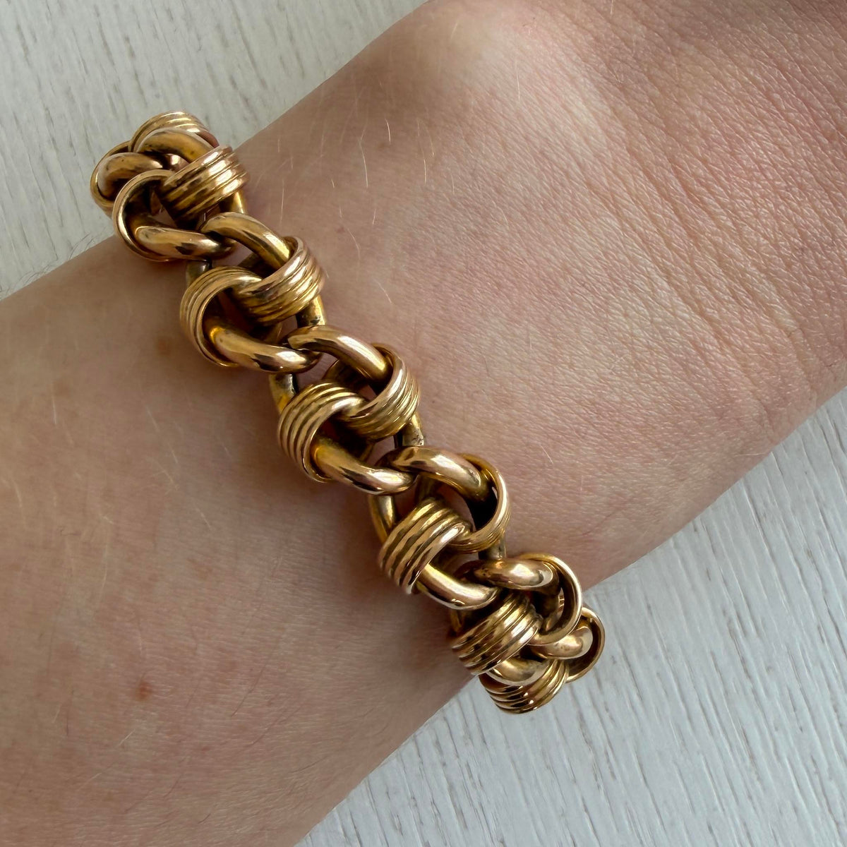 Victorian 15K yellow gold fancy link bracelet worn on a wrist, showing the alternating polished and ribbed links.
