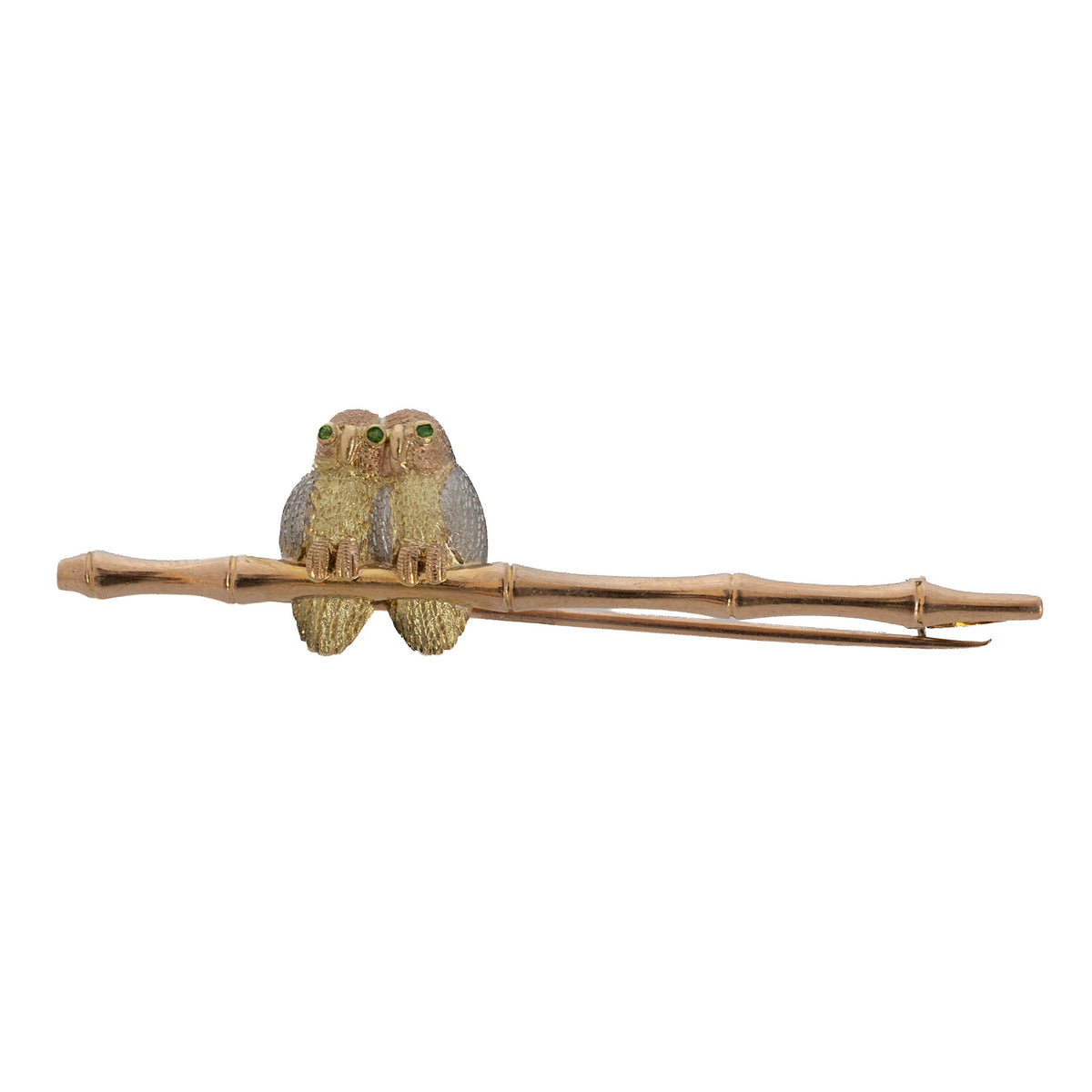 Vintage pin featuring two owls with green eyes and textured feathers perched on a bamboo-style bar.
