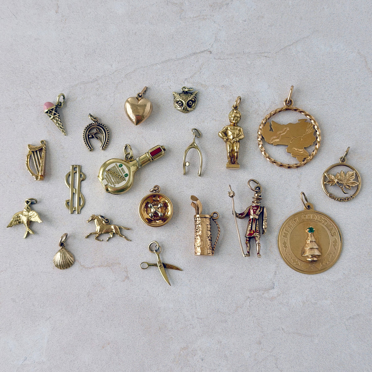 Vintage 14K Gold Wishbone Charm, Vintage 14K Gold Enamel Curaçao Liqueur Bottle Charm, Vintage 14K Gold Manneken Pis Statue Charm, Vintage 18K Gold Venezuela Silhouette Charm, Vintage 14K Gold Roulette Wheel Charm, Vintage 10K Gold Canadian Maple Leaf Charm, Vintage 14K Gold Merry Christmas Holiday Tree Disc Charm, Vintage 18K Gold Golf Clubs Bag Charm, Vintage 14K Gold Harp Charm, Vintage 14K Gold Puffed Heart Charm, Vintage 14K Gold Shell Charm, Vintage 10K Gold $ Dollar Sign Charm