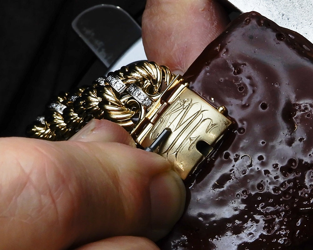 hand engraving a monogram on a club bracelet